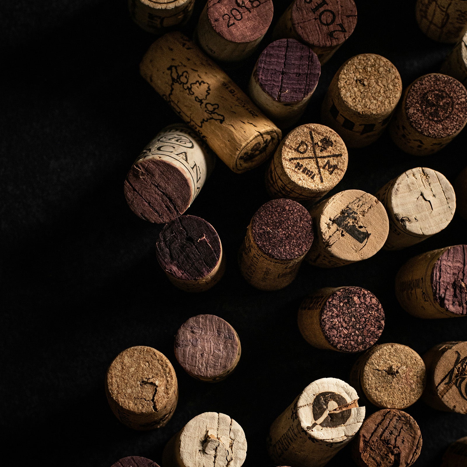 Collection of wine corks with various designs on a dark background